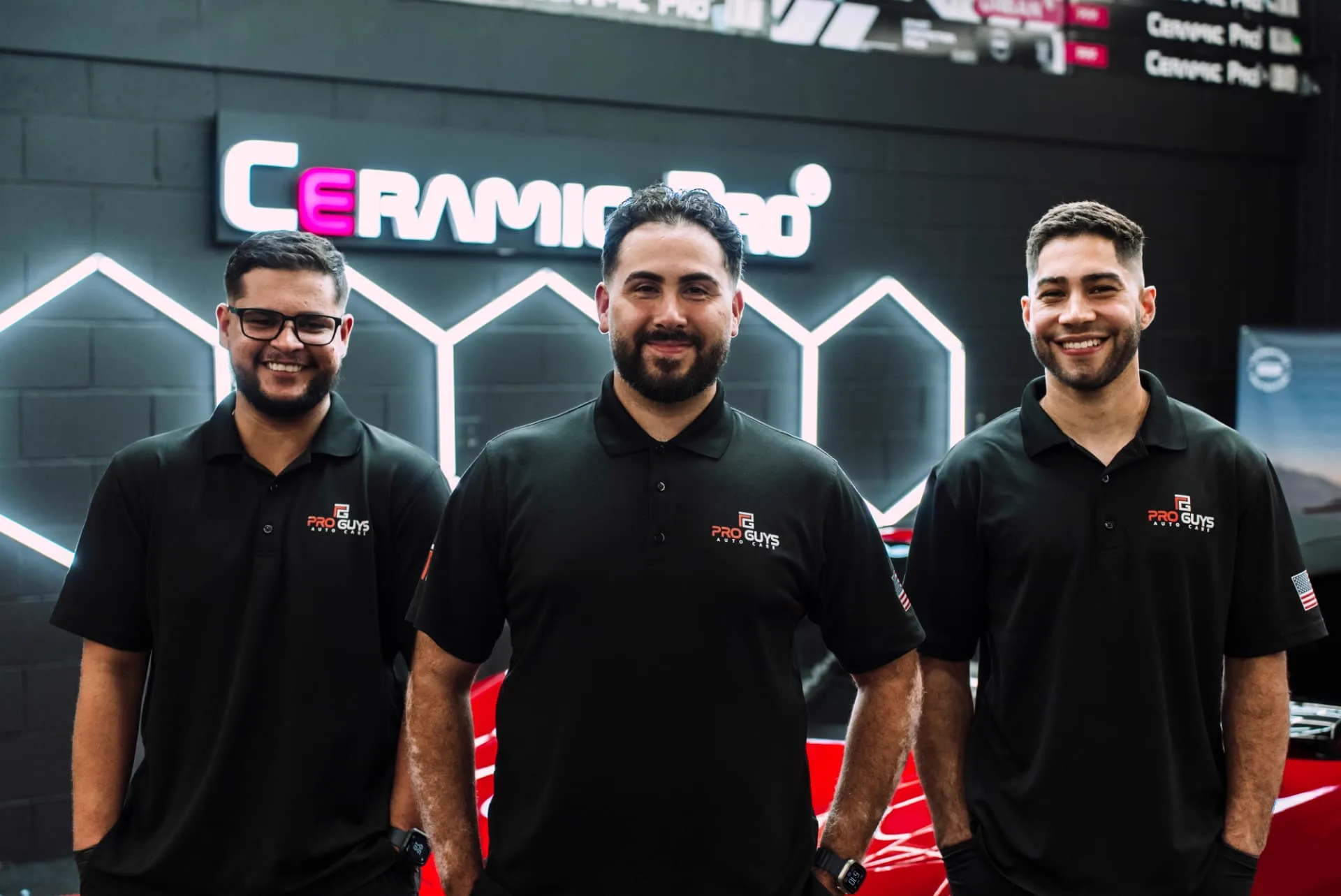 Three members of the PROGUYS Auto Care team inside the workshop