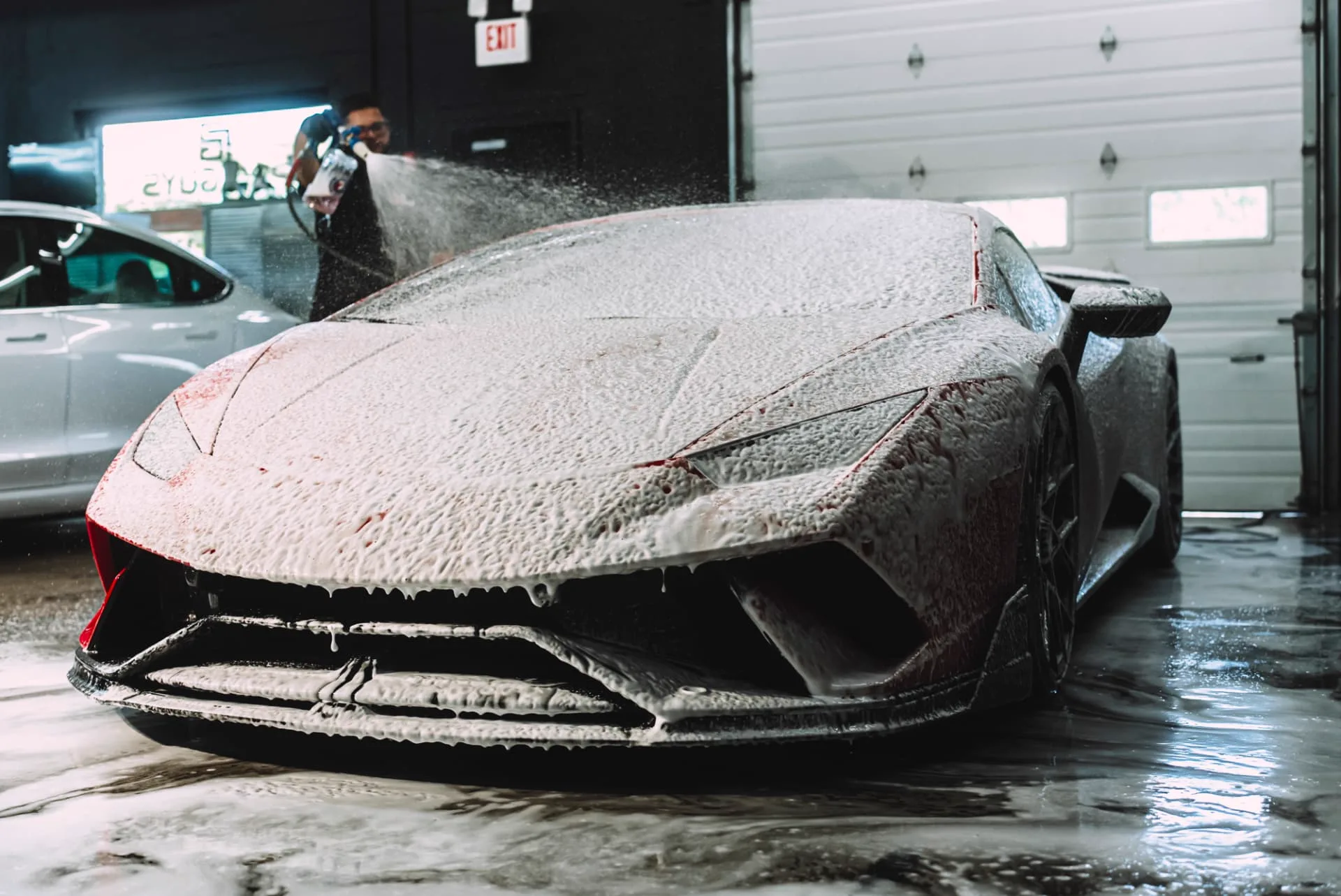 PROGUYS technician foam washing a red Lamborghini
