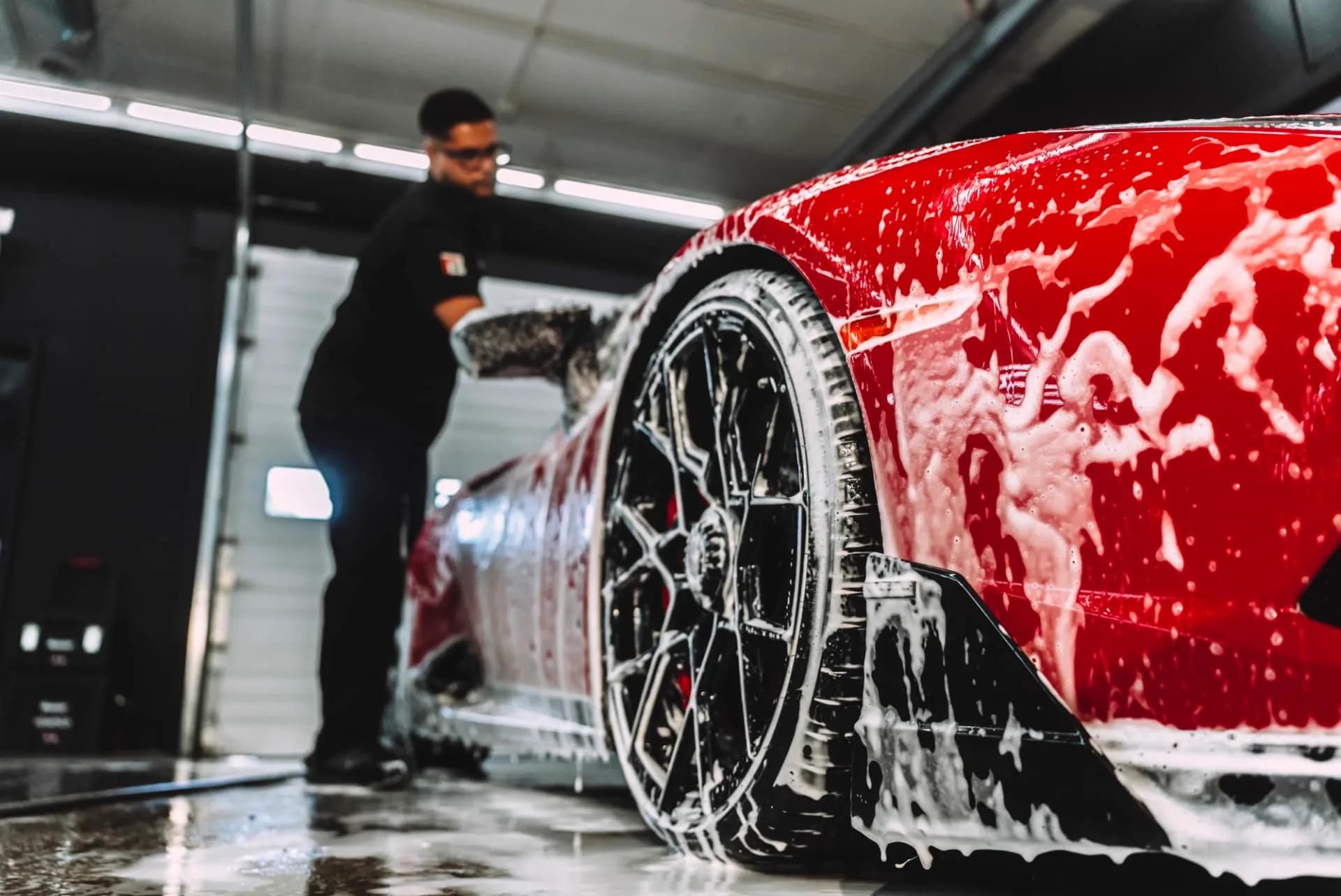 PROGUYS technician hand washing a red sports car